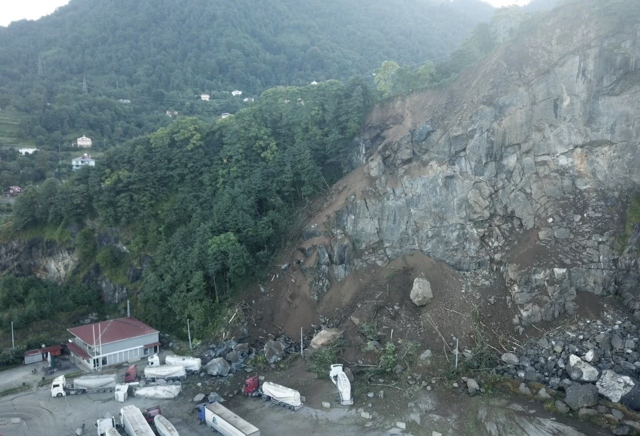 Yamaçtan kopan kayalar ve tır parkındaki araçlar