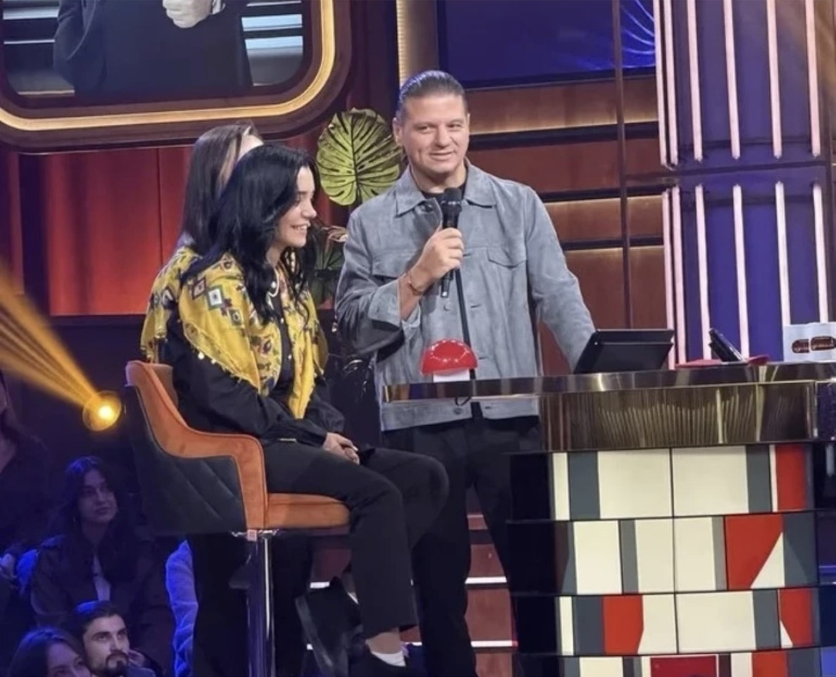 Beyaz'la Joker'de Kubat, sarı şallı yarışmacının yanında mikrofonla konuşuyor